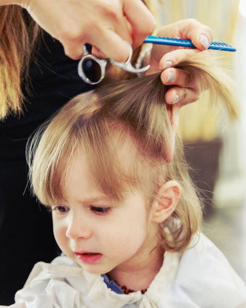 Male child at the hairdresser Male child gets his first haircut körperpflege stock pictures, royalty-free photos & images