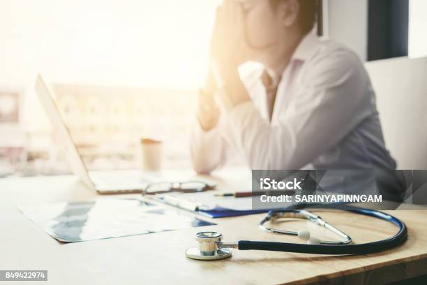 Stethoscope And Doctor Sitting With Laptop Stress Headache About Work In Hospital Stock Photo - Download Image Now