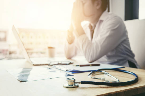 stethoscope and doctor sitting with laptop  stress headache about work in hospital - medicine cabinet medicine healthcare and medicine cabinet imagens e fotografias de stock