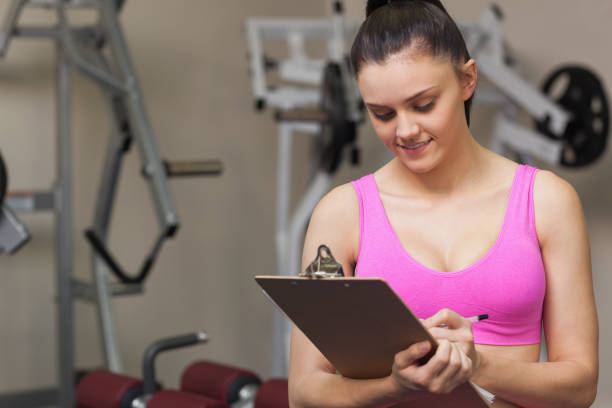 istock Female trainer writing on clipboard in gym 849436874