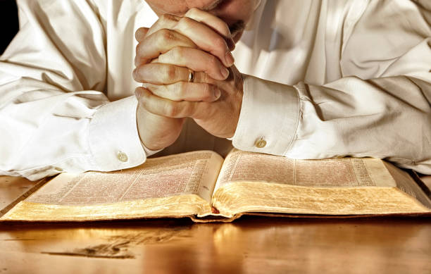 istock Man in Deep Prayer Over a Holy Bible 849442836