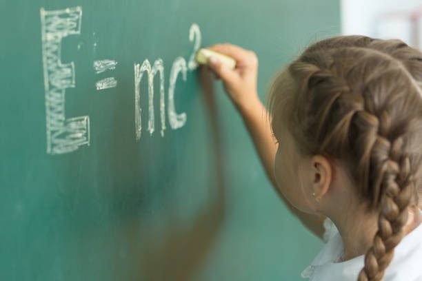istock Girl drawing on chalkboard formula e=mc2. Education and school concept 849449640