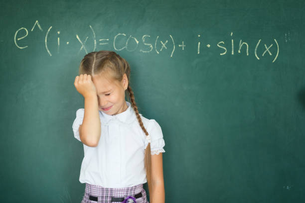 istock Child girl schoolgirl and compound formula on the chalkboard. Complex school program does not match the age of the child 849449806