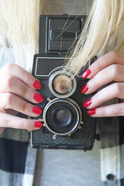 female holding vintage camera