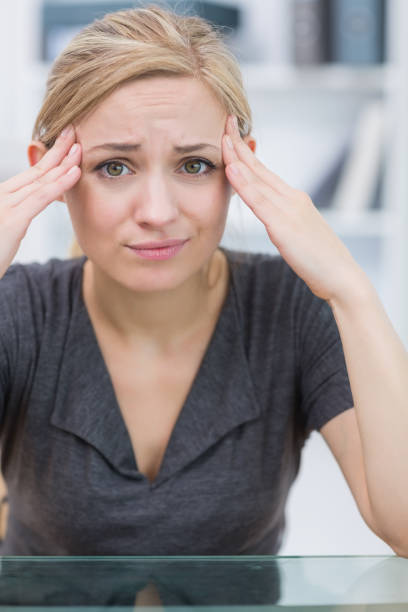 istock Frustrated business woman rubbing her temples at office 849454674