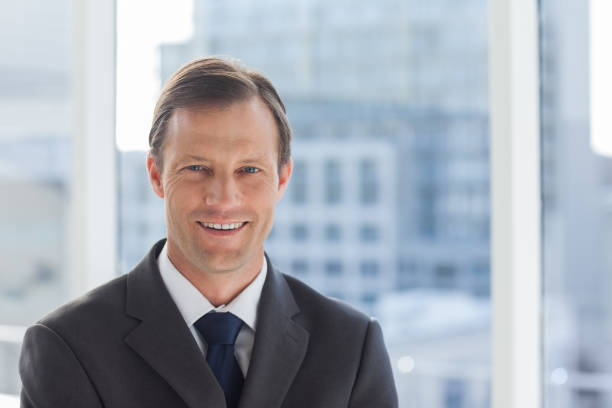 Headshot portrait of mature real estate agent businessman standing in office hall lobby