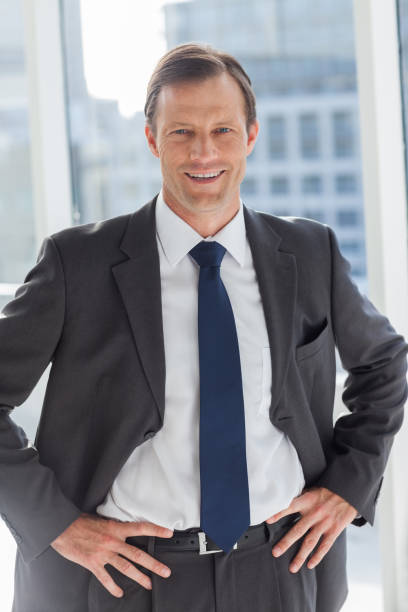 istock Smiling businessman with his hands on hips 849455476