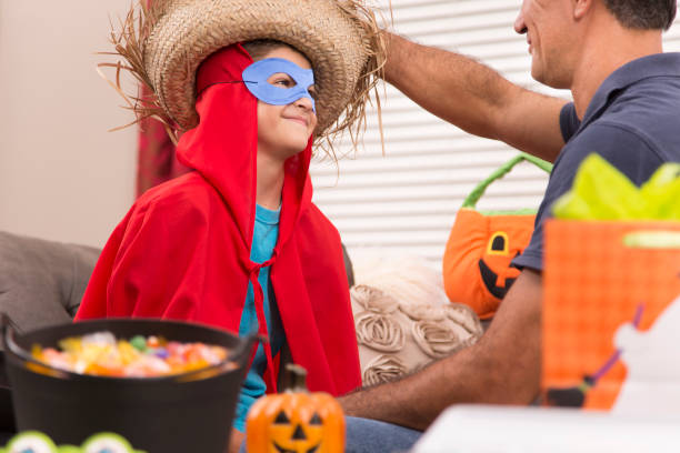 istock Little boy dresses up for Halloween with dad's help. 849461228