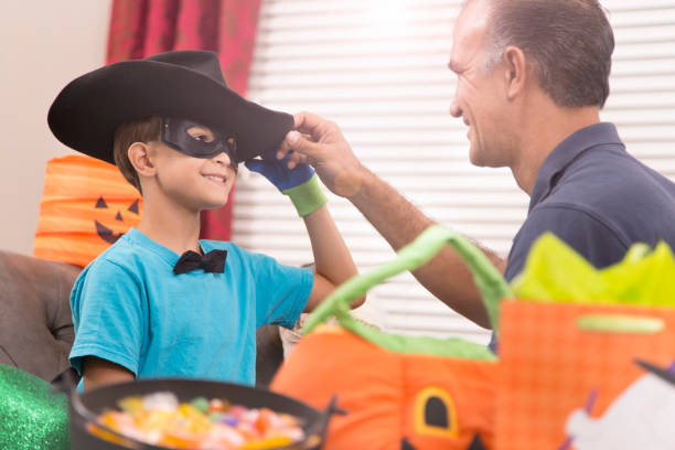 istock Little boy dresses up for Halloween with dad's help. 849461570