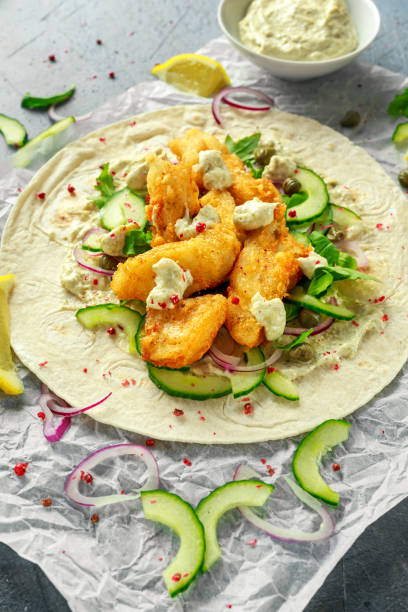 tortilla de pescado fresco con pepino, cebolla roja, alcaparras, limón, hojas de ensalada y salsa tártara. alimentos saludables - tuna salad sandwich fotografías e imágenes de stock