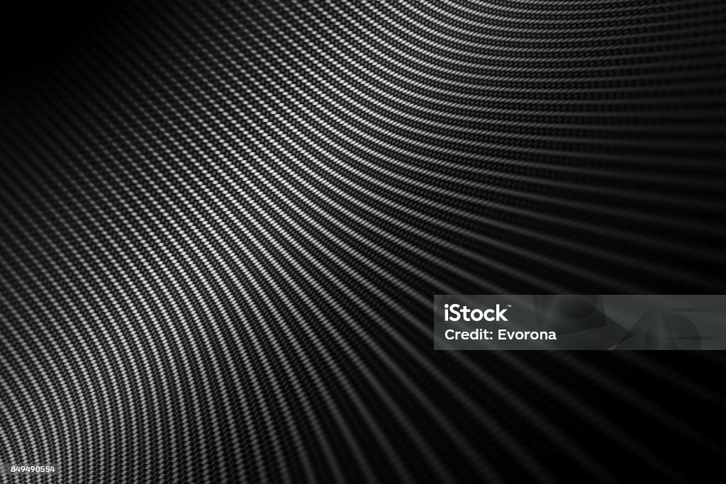 Distorted black carbon fiber smooth on surface. Modern background with distorted black carbon fiber smooth on surface under angle. Car Stock Photo