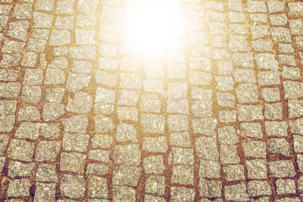 Abstract background of old cobblestone pavement texture with natural patterns view from above. Vintage tone