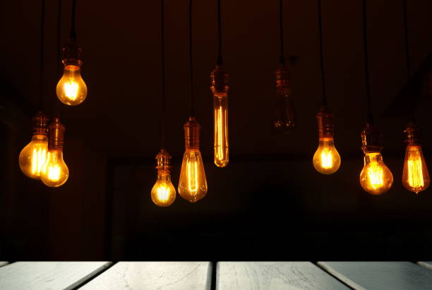 istock lamp light with black top table wood display background at dark night 849525958