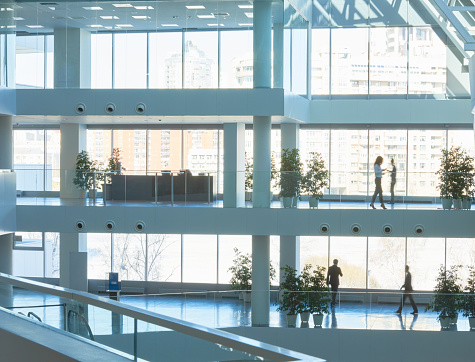 Office building interior with several floors where business people walking