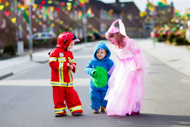 Kids on Halloween trick or treat. Kids on Halloween trick or treat. Children in Halloween costumes with candy bags walking in decorated city neighborhood trick or treating. Baby and preschooler celebrating carnival wearing costume. carnival children stock pictures, royalty-free photos & images