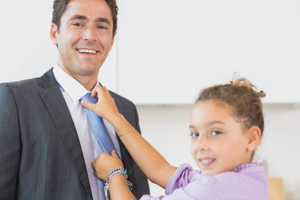 istock Smiling daughter fixing fathers tie 849546468
