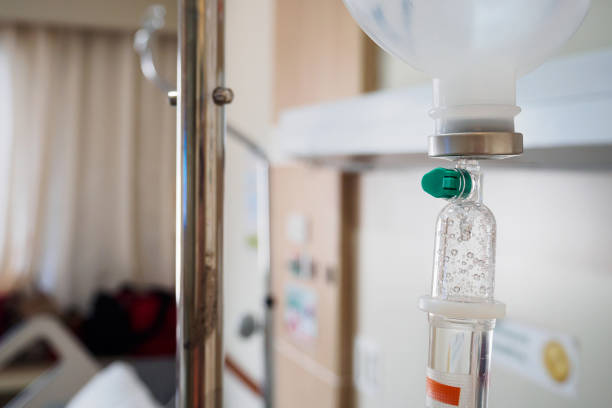 istock Medical drip with hospital blurred background 849555804