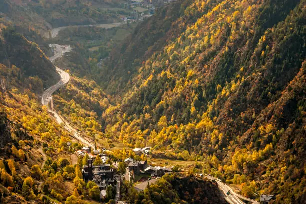 Main highway in Andorra winds, near the Meritxell chapel, through a valley, at the peak of fall faliage colors