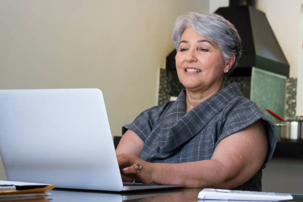 Senior Brazilian woman using laptop together at home stock photo