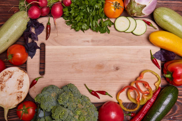 istock Fresh Vegetables on white cutting board and brown wooden background. 849581418