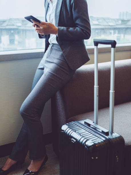 istock cropped image of woman sitting by window using smartphone 849592646