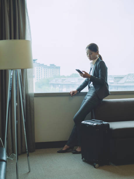 istock woman sitting by window using smartphone 849593118