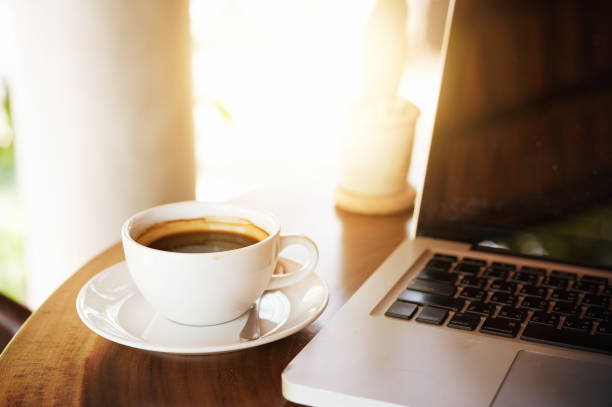 istock Cup of coffee and laptop on wooden table 849593718