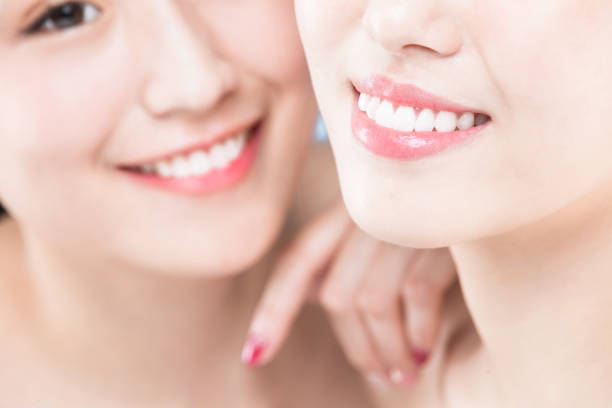 two beauty woman with healthy teeth on the blue background