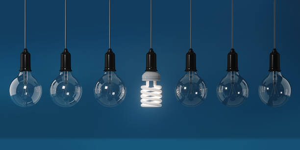 istock Energy Saving Light Bulb Standing Out From The Crowd Over Blue Background: Energy Efficiency and Standing Out From The Crowd Concept 849625502