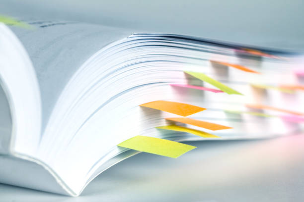 Close up White book marked by sticky note Close up White book marked by sticky note handbook photos stock pictures, royalty-free photos & images