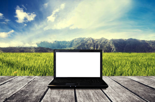Laptop computer blank white screen on wooden table at countryside. Clipping path on screen