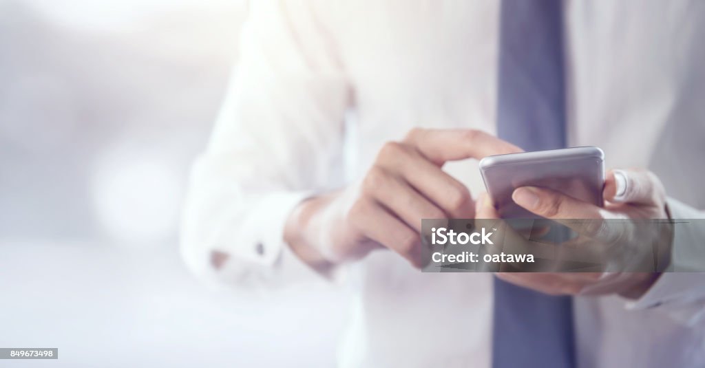 Cerca de un hombre de negocios con teléfonos móviles. - Foto de stock de Teléfono inteligente libre de derechos