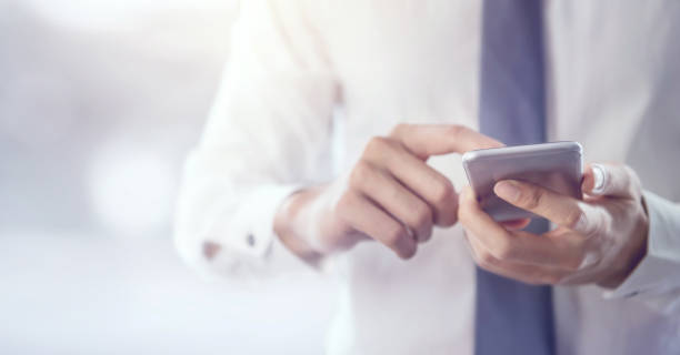 Close up of a business man using mobile smart phone.
