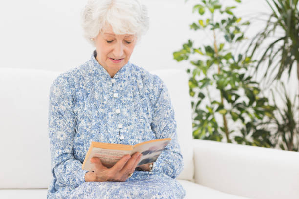 istock Elderly woman reading a old book 849673892