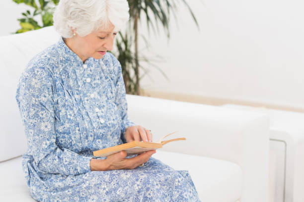 istock Elderly calm woman reading a old book 849673902