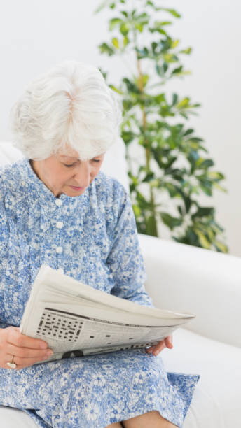 istock Elderly cheerful woman reading newspapers 849676212