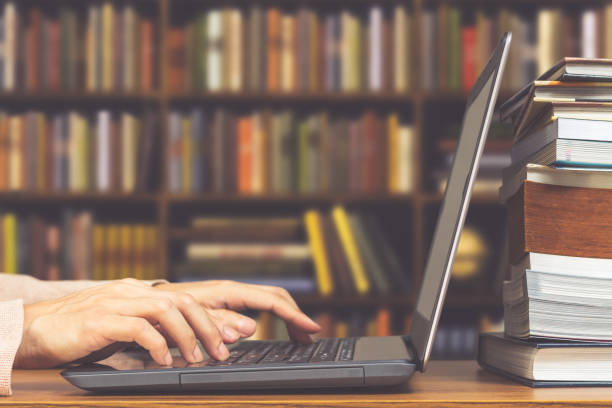 männliche schüler hände machen forschung auf laptop und internet für die vorbereitung der prüfung und lehren in bibliothek durchsuchen - bibliothekar stock-fotos und bilder