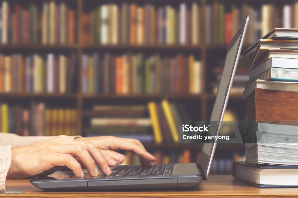 male student hands making research on laptop and browse internet for preparing exam and learning lessons in library Author Stock Photo