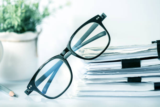 istock Close up black reading eyeglasses on the  stacking of office paper , business working document and information data concept. 849686728