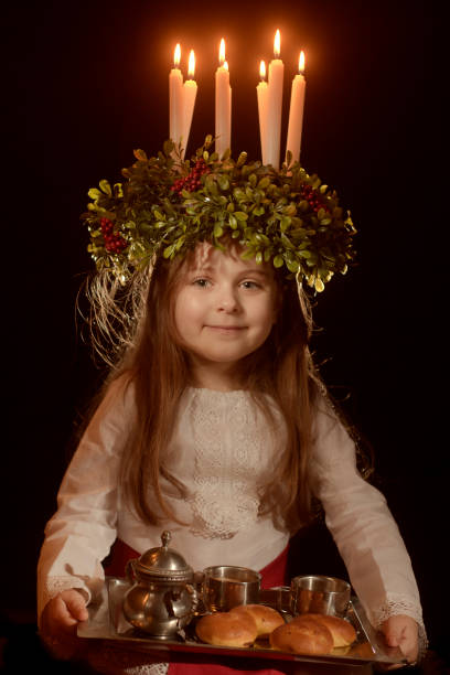 Little caucasian girl in Saint Lucia costume Little caucasian girl in Saint Lucia costume with crown of candles and traditional swedish sweet cirque de soleil stock pictures, royalty-free photos & images