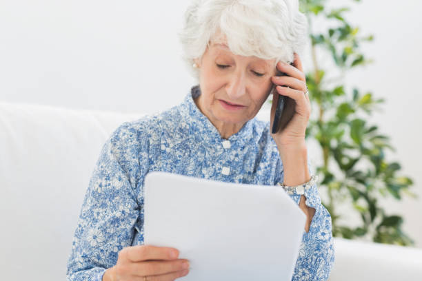 istock Elderly woman reading papers on the phone 849696562