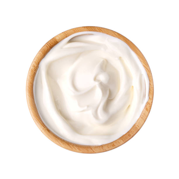crème sure dans un bol en bois isolé sur blanc. produit laitier. vue de dessus. - bowl photos et images de collection
