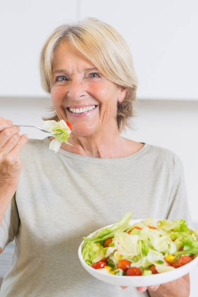 istock Smiling mature woman eating salad 849720316
