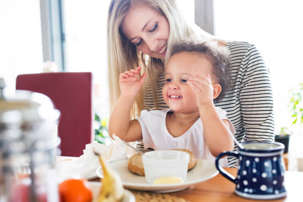 istock Beautiful young mother with his daughter having breakfast. 849736422