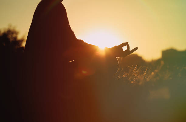 Woman meditating in yoga dancer(Natarajasana) pose silhouette over ocean and islands, coastline and rocky mountains. Inspiration and  motivation with healthy lifestyle in beautiful sunset landscape, fitness concept.