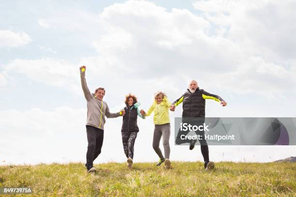 Group Of Senior Runners Outdoors Resting Holding Hands Stock Photo - Download Image Now