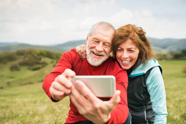aktive ältere läufer in der natur fotografieren mit ihrem smartphone. - action senior adult lifestyles couple stock-fotos und bilder