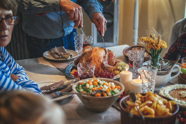 istock Grandfather Carving Stuffed Turkey for Holiday Dinner 849740986
