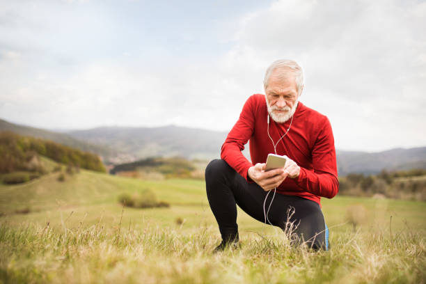 istock Active senior runner in nature with smart phone and earphones. 849741104