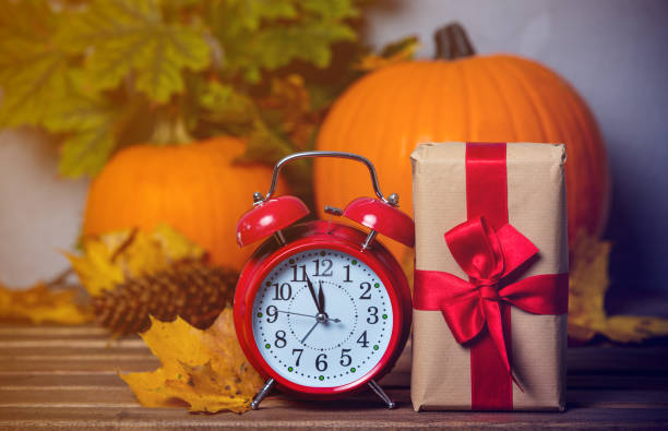 istock alarm clock with leaves and pumpkin with Halloween gift box 849741346